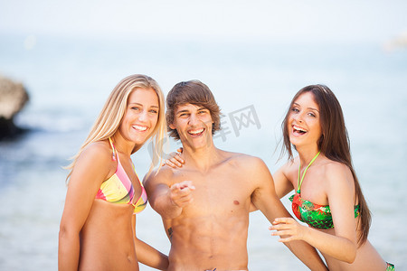 三个年轻漂亮的朋友在沙滩上玩得开心