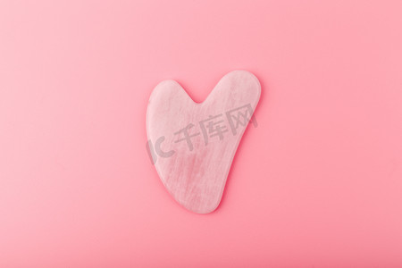 沙石logo摄影照片_粉红色心形瓜沙石，由亮粉色背景上的石英晶体制成