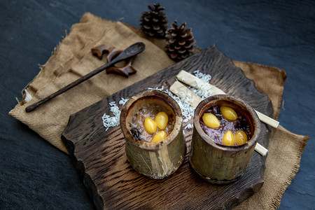 竹节线稿摄影照片_用椰奶 (Khao lam) 煮熟的糯米或在木制的泰国甜点概念上的竹节中烤的糯米。
