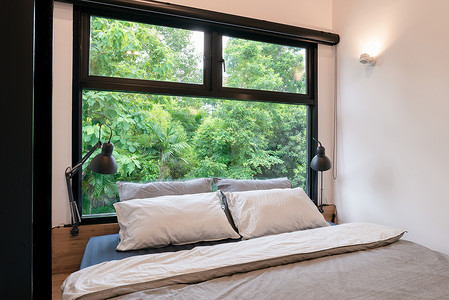 窗外有清新自然绿树景的卧室