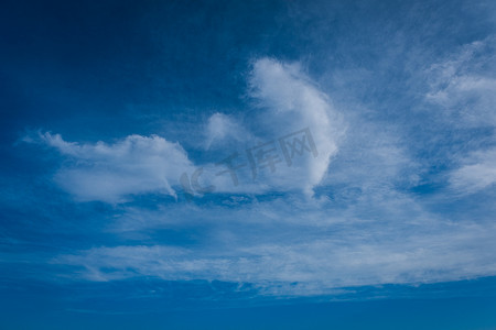 美丽的云彩背景，清晰可见的白云和蓝天线条，顶部是一道阳光