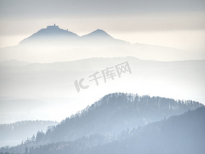 景观中圆形山丘上方的蓝色薄雾。