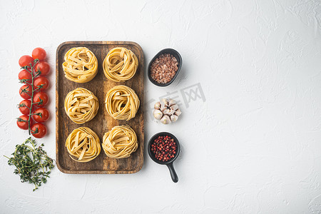 Raw tagliatelle 嵌套传统意大利面食，在白色石头背景上，顶视图平铺，带有文本复制空间