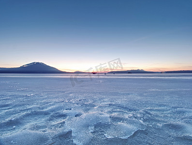 阿拉泰摄影照片_令人叹为观止的日落，蓝色粉红色的云彩覆盖着结冰的湖面