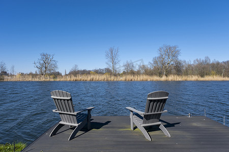 俯瞰河流的木甲板上质朴的手工椅子