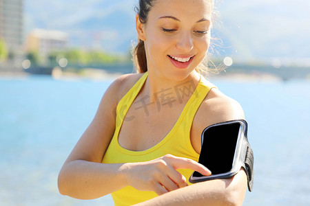 跑步运动员从智能手机 mp3 播放器智能手机臂章中听音乐。