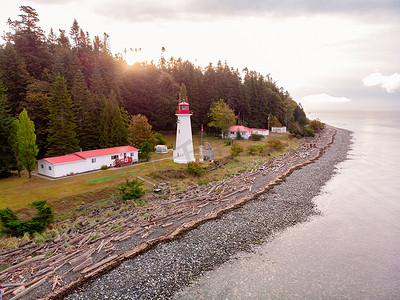加拿大温哥华岛，Quadra Island 老历史灯塔在马奇角夫妇在海岸风暴期间穿着黄色雨衣