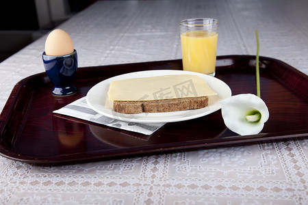 “盘子里的早餐有面包、奶酪、鸡蛋和橙汁”
