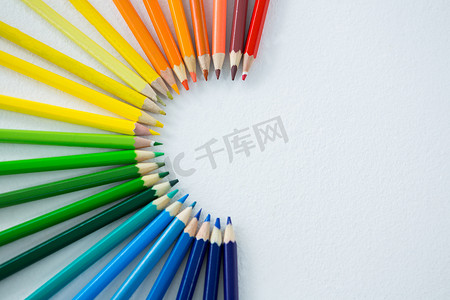 在白色背景上排列成半圆的彩色铅笔