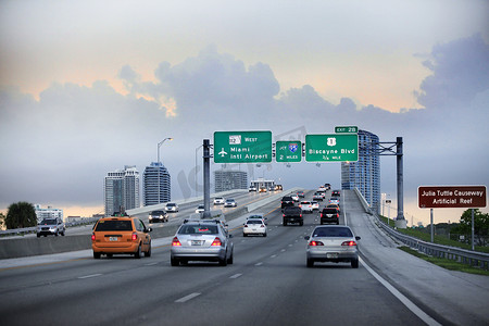 汽车在高速公路上行驶，带有指向迈阿密国际机场的方向标志