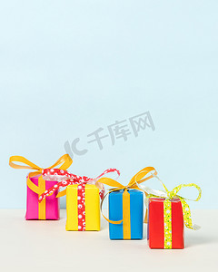 柔和背景上的四个彩色礼品盒。