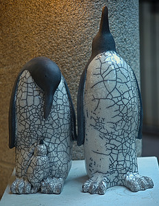 小企鹅摄影照片_木架上的企鹅陶瓷雕像