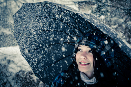 暴风雪中带伞的年轻女子