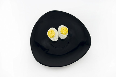 鹌鹑蛋放在黑色碟子上，与白色隔离