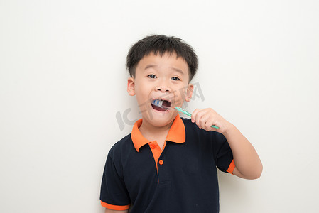 白色背景下刷牙的小男孩