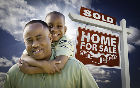 非洲裔美国父亲带着儿子在出售的待售房屋前