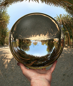 透视正方体摄影照片_手中的玻璃球体。