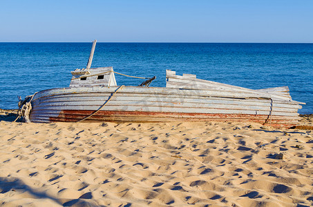 躺在海边的旧木渔船