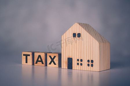 木块立方体与 TAX 词和家庭模型、房地产和财产关于财务、财务规划、住宅和税收投资、预算和税收、商业概念。