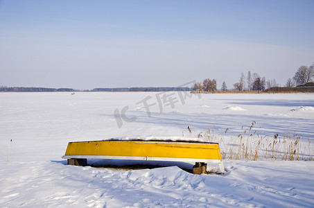冬季湖岸上的黄色小船