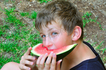 一个男孩拿着一片西瓜