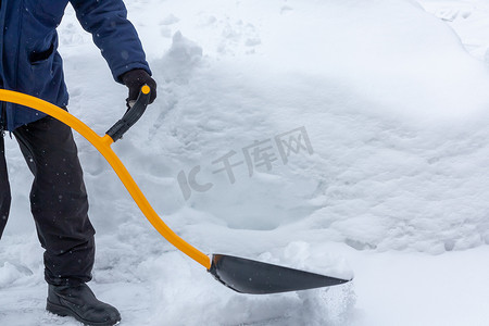 大雪过后，一个男人用铲子清理院子里的雪fa