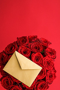 信封书信摄影照片_情人节的情书和送花服务、豪华的红玫瑰花束和红色背景的卡片信封