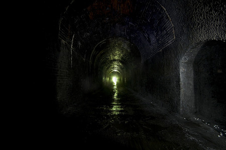 拱形隧道摄影照片_废弃铁路隧道的黑暗