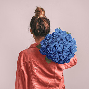 拿着经典蓝玫瑰的女人的背影