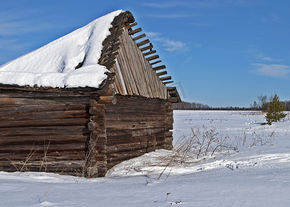 冬季雪下屋顶破损的旧谷仓