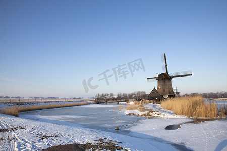 风车雪摄影照片_在冬时的风车与雪和蓝天