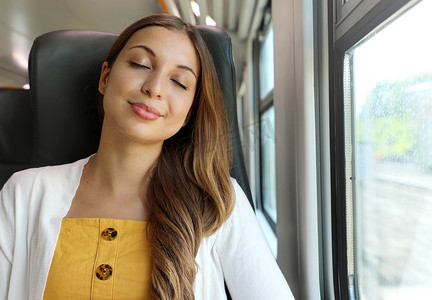 疲惫的女商人在一天的工作后坐在火车上睡觉。