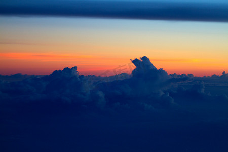 窗口日落摄影照片_从飞机窗口看到的云层上方的日落景色