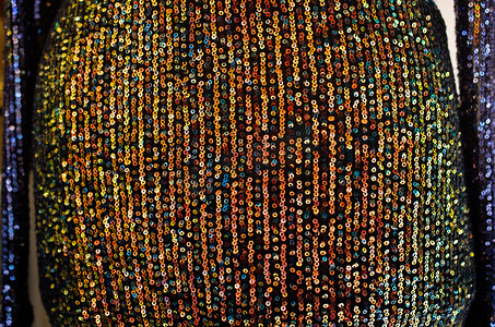 闪粉亮片皮革摄影照片_亮片抽象序列织物纺织闪光背景。