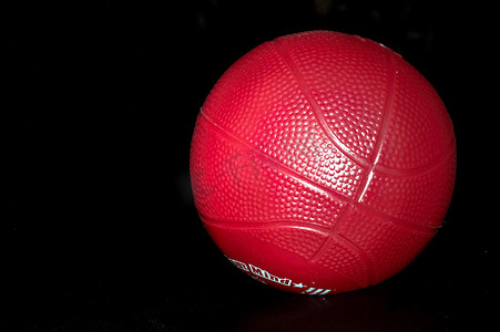 黑色背景中的红色玩具篮球