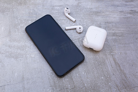 app蓝摄影照片_带白色无线耳机的黑色豪华智能手机