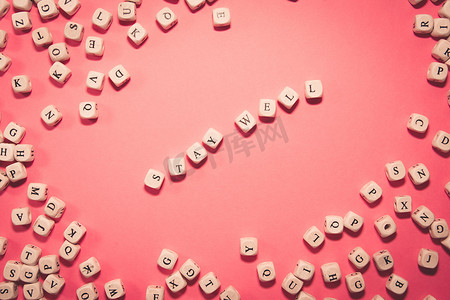 粉红色柔和背景上的白色骰子，带有保持健康的信息、健康和生活理念