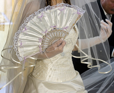 有白色礼服和扇子的新娘