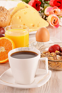 “桌上的早餐。咖啡、橙汁、面包卷、牛奶什锦早餐。”