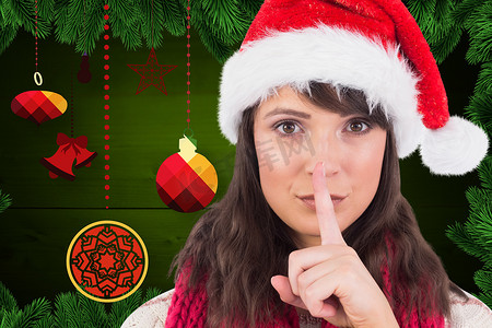 圣诞帽绿色摄影照片_在数字生成的圣诞节背景下，戴着圣诞帽、手指放在嘴唇上的女人