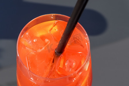 在蓝天背景下加冰的清爽橙色夏季鸡尾酒。