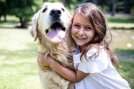微笑的女孩和她的宠物狗在公园里