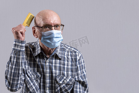 秃头老头戴着眼镜，戴着医用面具，手里拿着梳子。