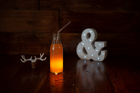 木制背景上的一瓶老式鲜榨果汁和一个发光的符号。