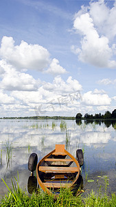 木船河上摄影照片_夏日湖上的一艘木船