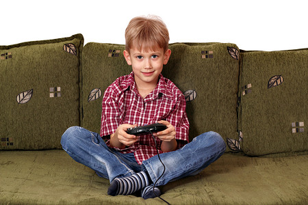 男孩坐在床上玩电子游戏