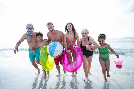 凉拌八代摄影照片_快乐的多代家庭在沙滩上奔跑