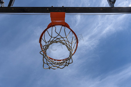 在万里无云的温暖夏日天空下，带红色圆环的篮球架