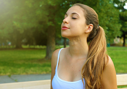 一个女人在公园里放松呼吸新鲜空气的画像。