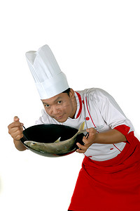 厨师在黑色油炸上呈现生鱼